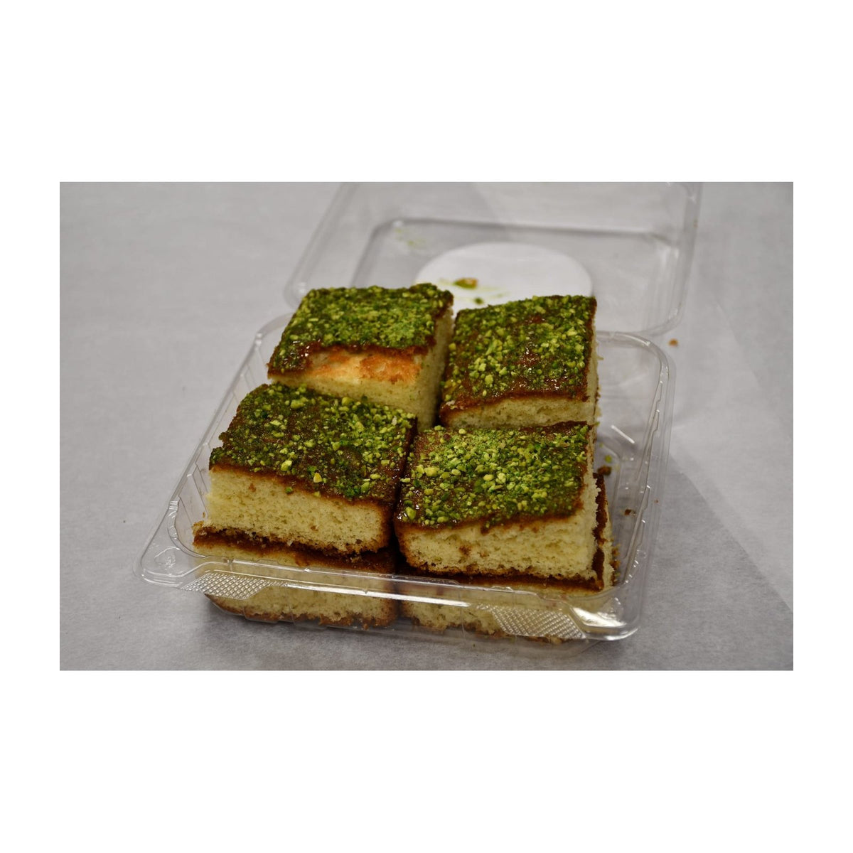 Sliced pistachio cake in a bakery package